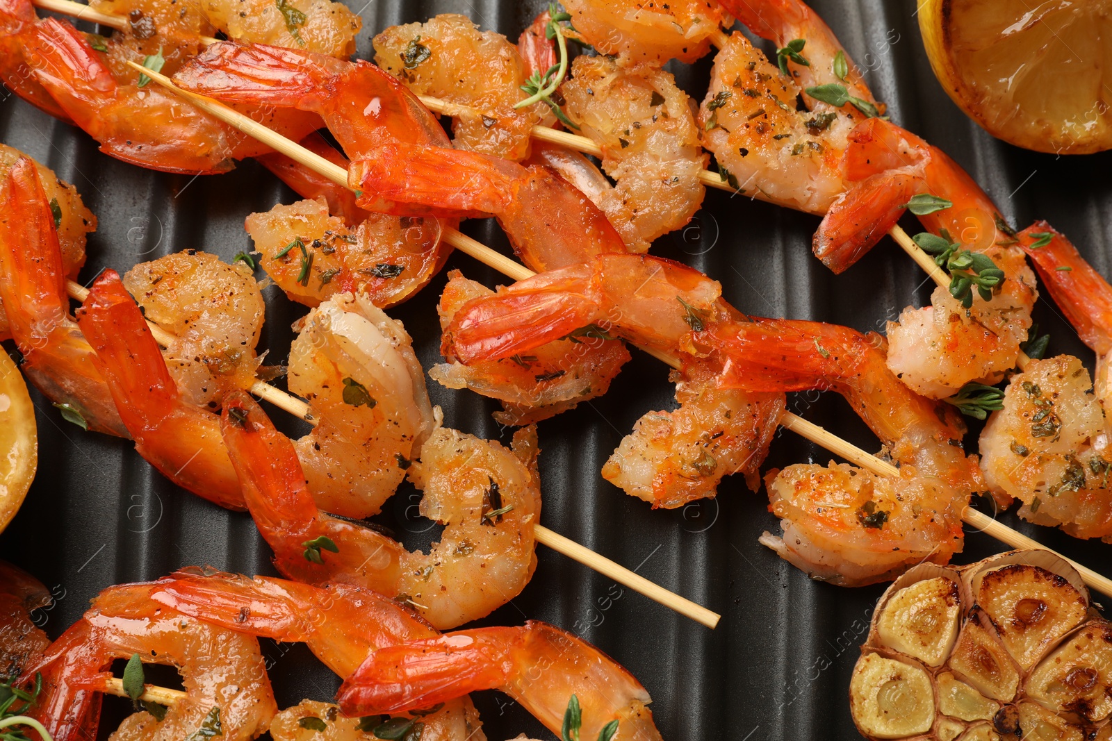 Photo of Skewers with delicious shrimps on grill pan, top view