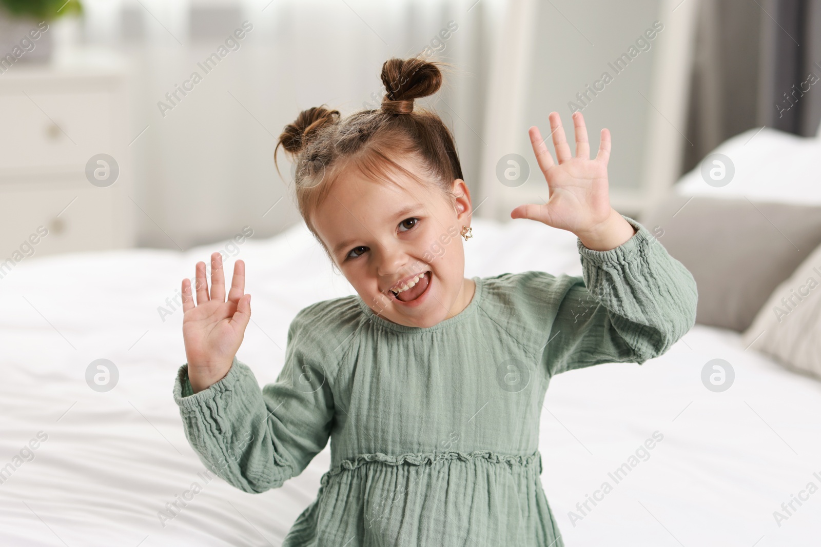 Photo of Portrait of happy little girl in bedroom