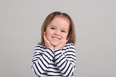 Photo of Portrait of happy little girl on grey background