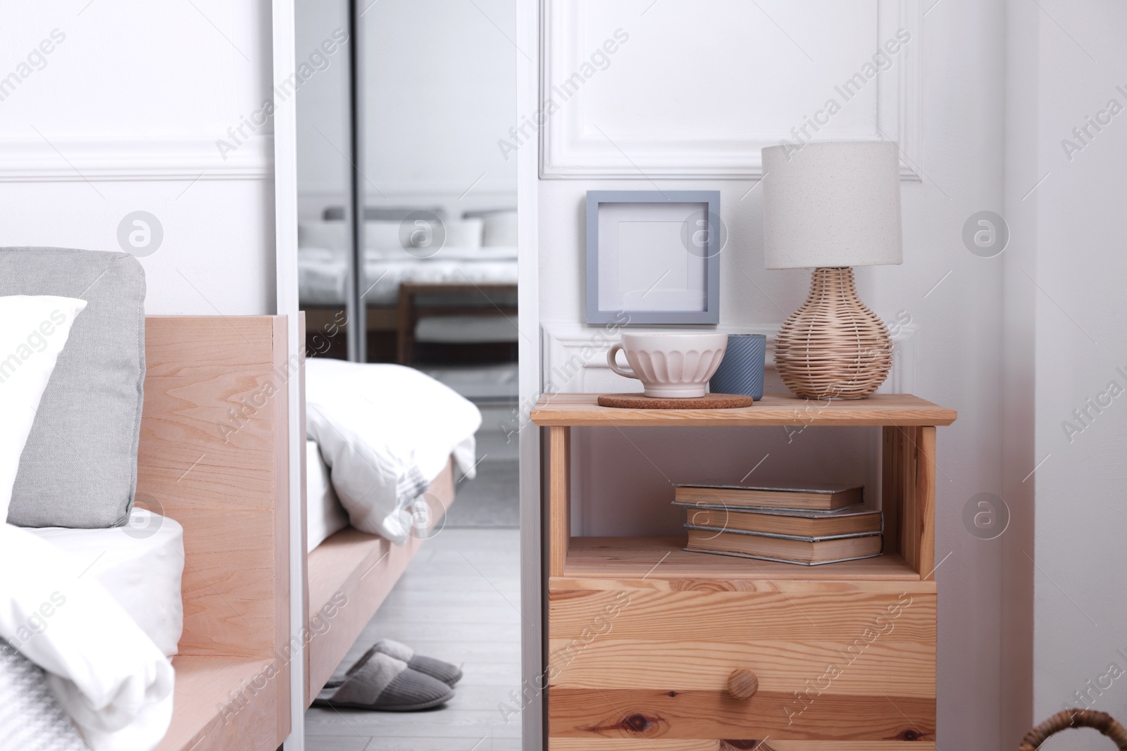 Photo of Stylish living room interior with bed, bedside table and lamp