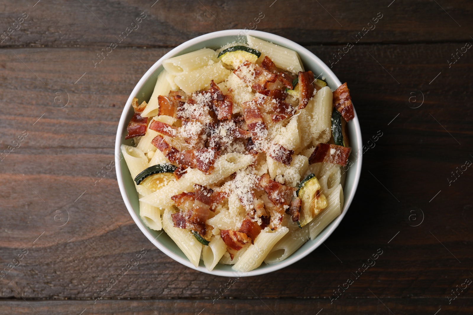 Photo of Tasty pasta with bacon and cheese on wooden table, top view