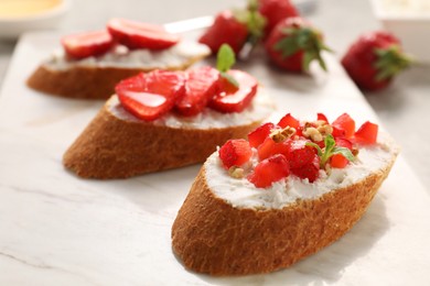 Delicious ricotta bruschettas with strawberry and mint on plate, closeup