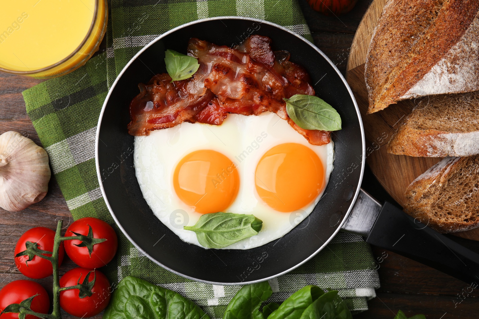 Photo of Fried eggs and bacon served on wooden table, top view