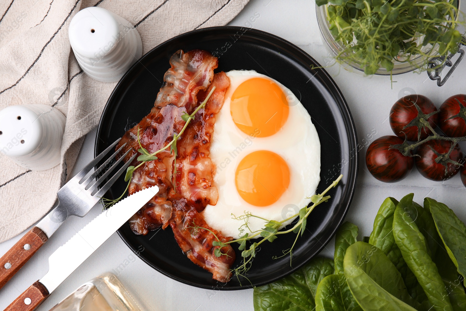 Photo of Fried eggs and bacon served on white table, top view