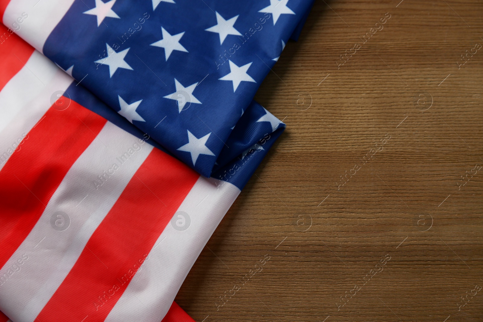 Photo of Flag of USA on wooden table, top view. Space for text