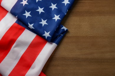 Photo of Flag of USA on wooden table, top view. Space for text