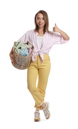 Photo of Happy young housewife with basket full of laundry on white background