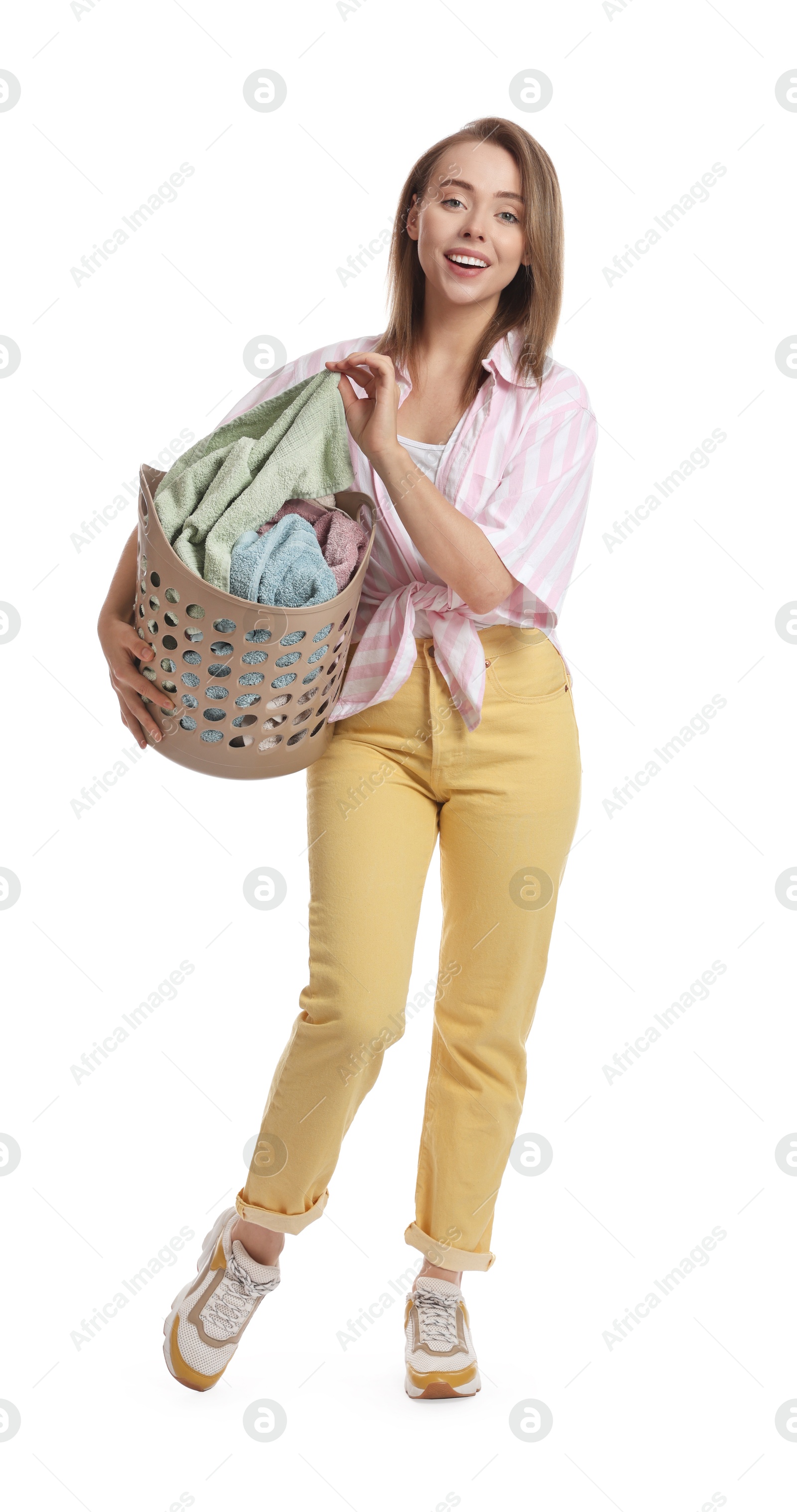 Photo of Happy young housewife with basket full of laundry on white background