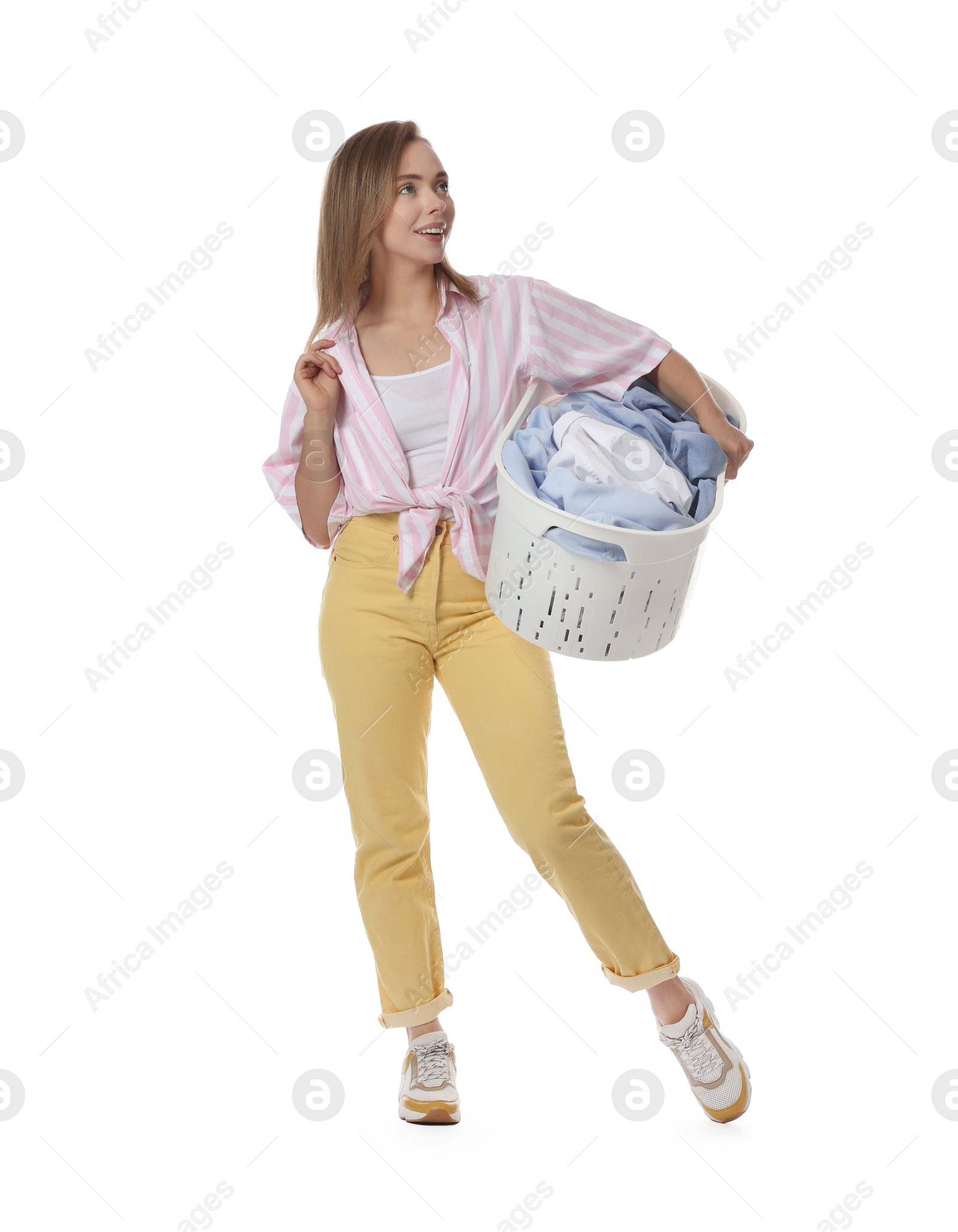 Photo of Happy young housewife with basket full of laundry on white background