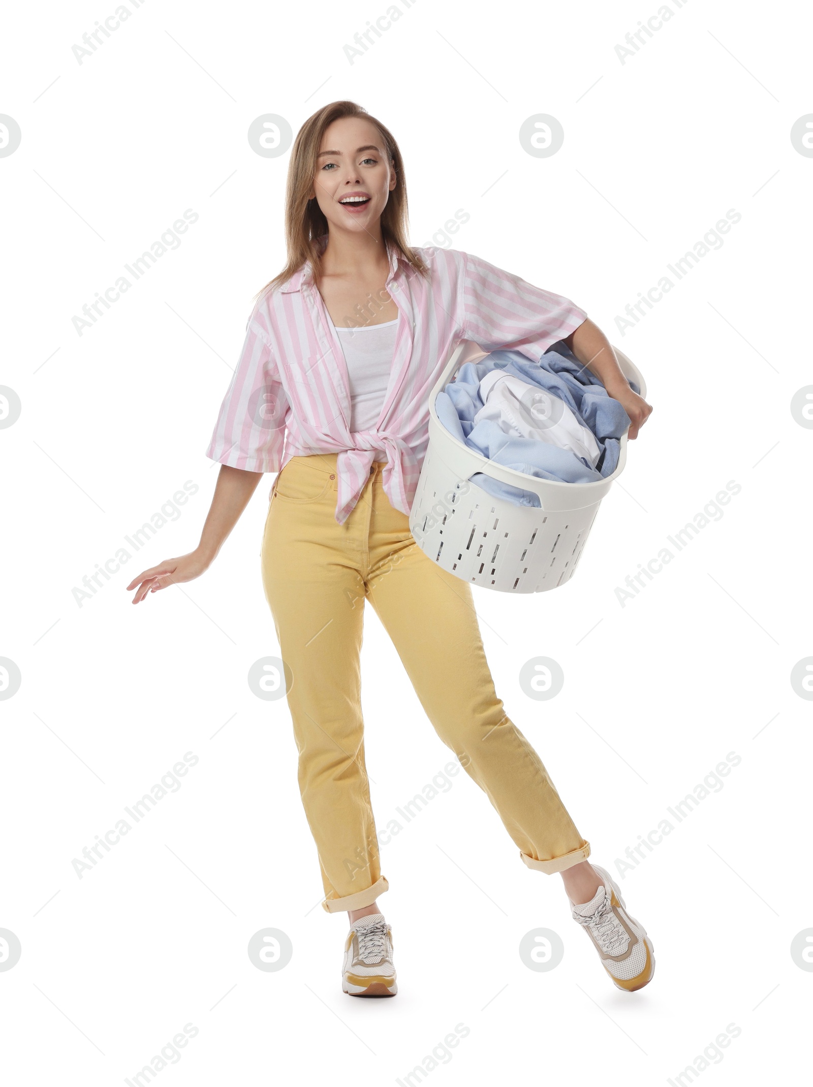 Photo of Happy young housewife with basket full of laundry on white background