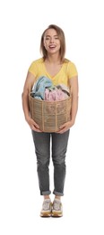 Happy young housewife with basket full of laundry on white background