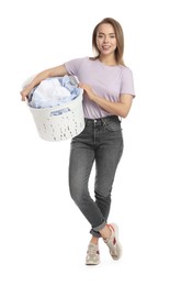 Happy young housewife with basket full of laundry on white background