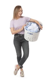 Happy young housewife with basket full of laundry on white background