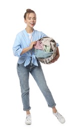 Happy young housewife with basket full of laundry on white background