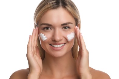 Beautiful woman with cream on her face against white background