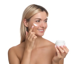 Beautiful woman applying face cream on white background