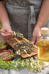 Senior woman making tincture at table outdoors, closeup