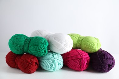 Photo of Many soft skeins of yarn on light grey background