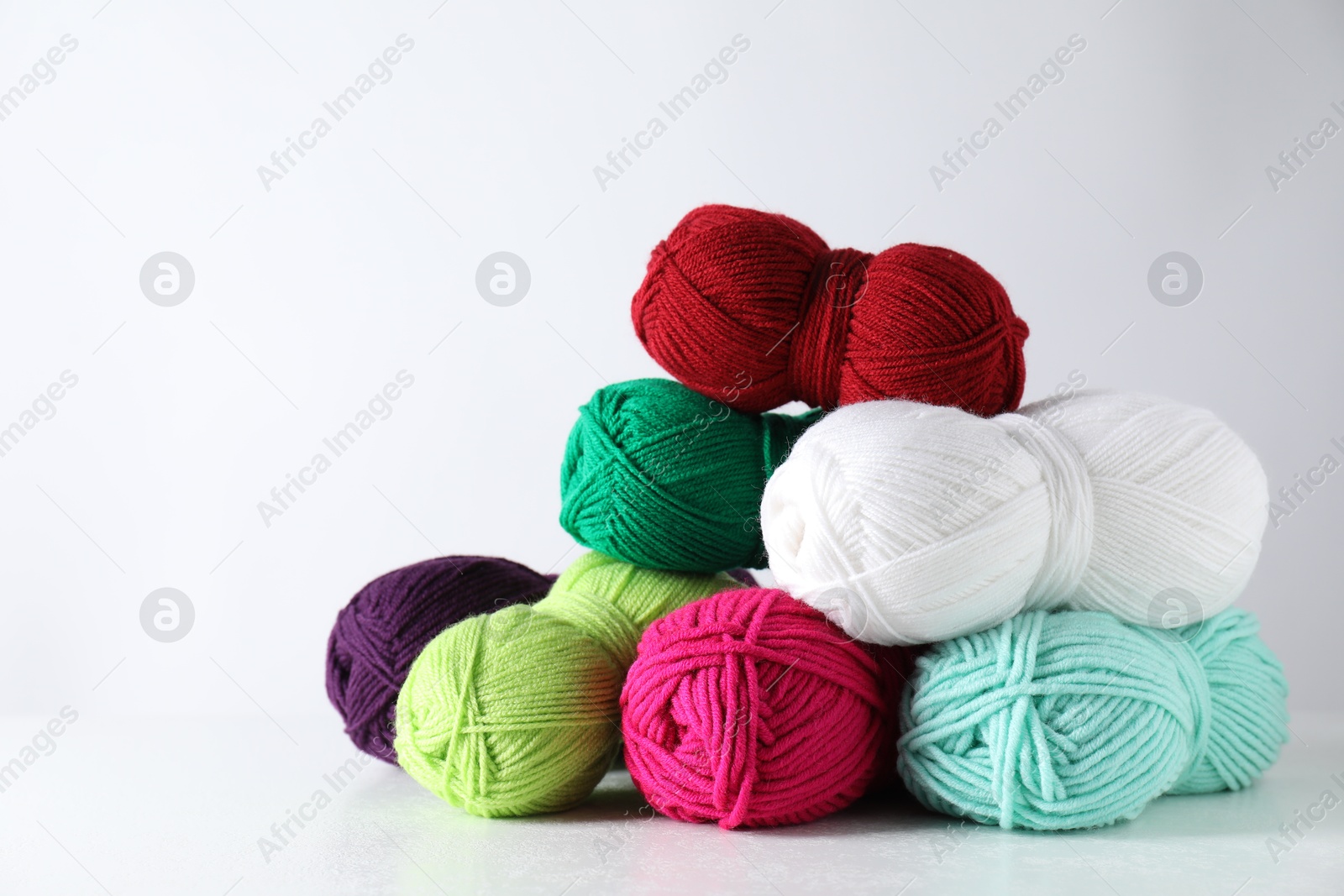 Photo of Many soft skeins of yarn on light grey background