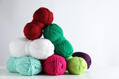 Photo of Many soft skeins of yarn on light grey background