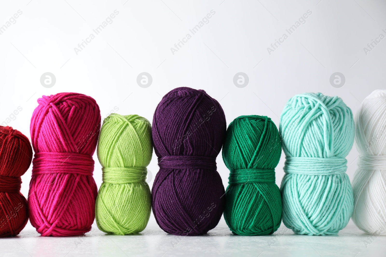 Photo of Many soft skeins of yarn on light grey background