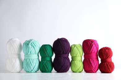 Photo of Many soft skeins of yarn on light grey background, space for text