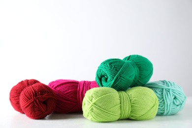 Photo of Many soft skeins of yarn on light grey background, space for text