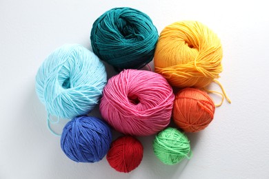 Many soft skeins of yarn on light grey background, flat lay