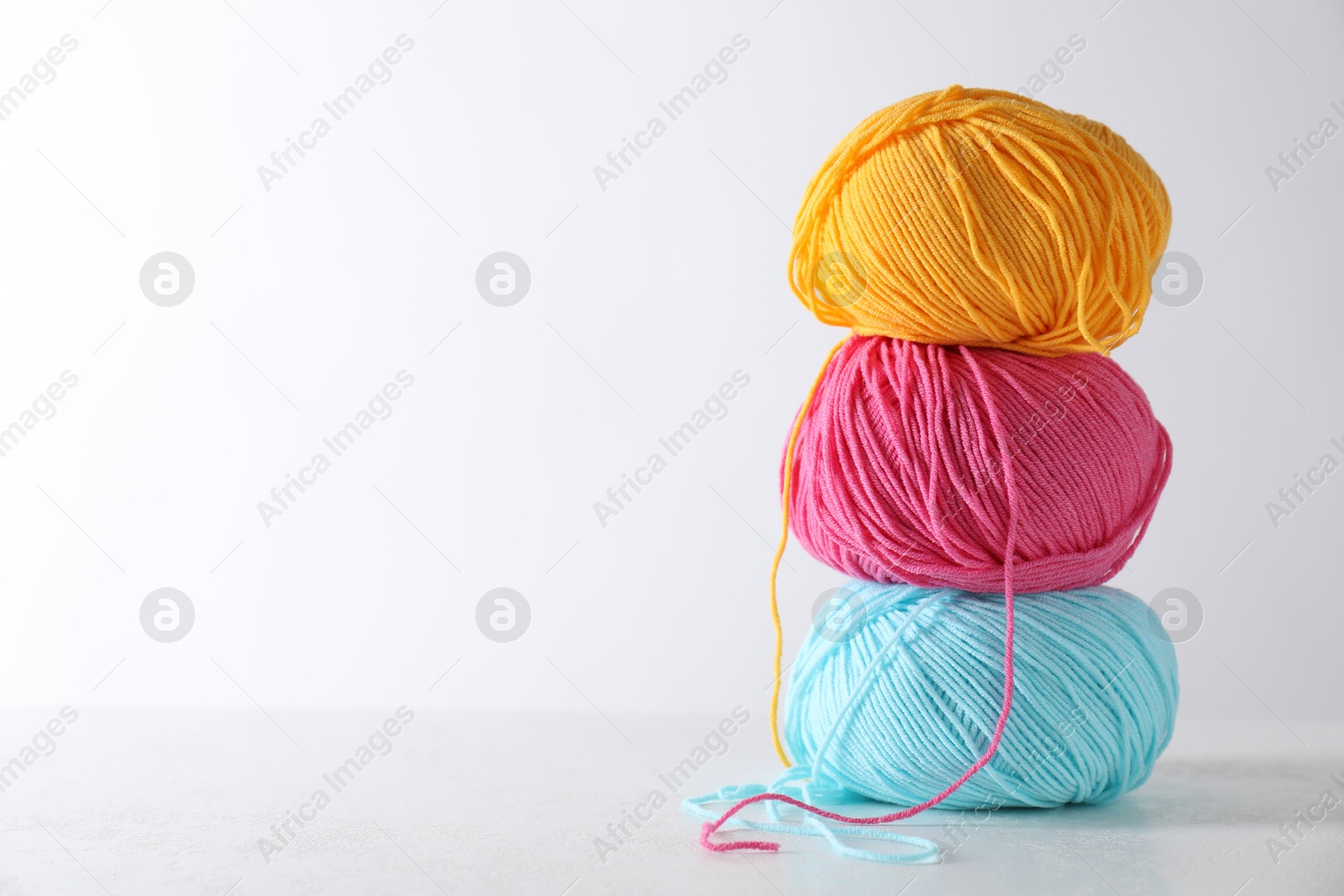 Photo of Many soft skeins of yarn on light grey background, space for text