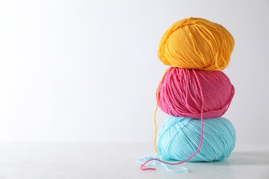 Photo of Many soft skeins of yarn on light grey background, space for text