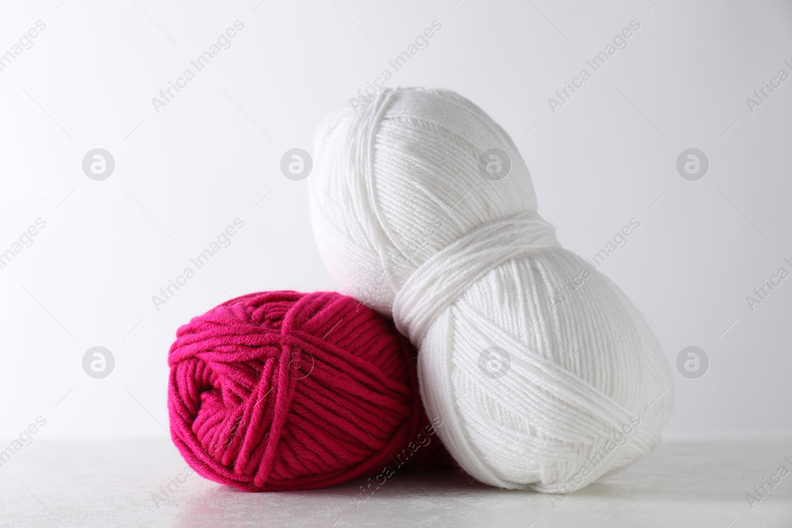 Photo of Two soft skeins of yarn on light grey background