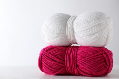 Photo of Two soft skeins of yarn on light grey background, space for text