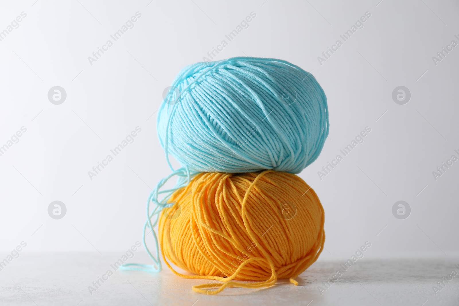 Photo of Two soft skeins of yarn on light grey background