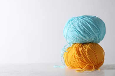 Two soft skeins of yarn on light grey background, space for text