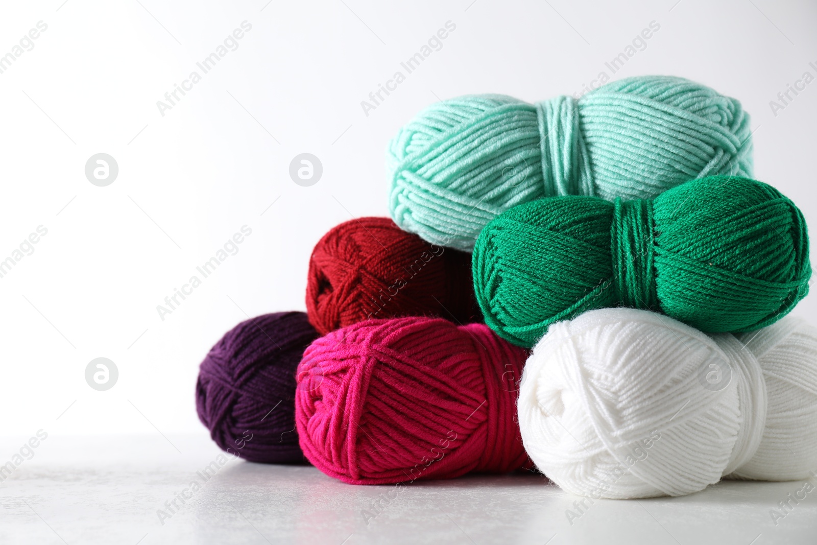 Photo of Many soft skeins of yarn on light grey background