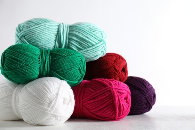 Photo of Many soft skeins of yarn on light grey background