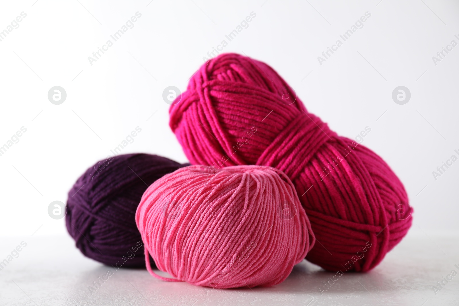 Photo of Many soft skeins of yarn on light grey background