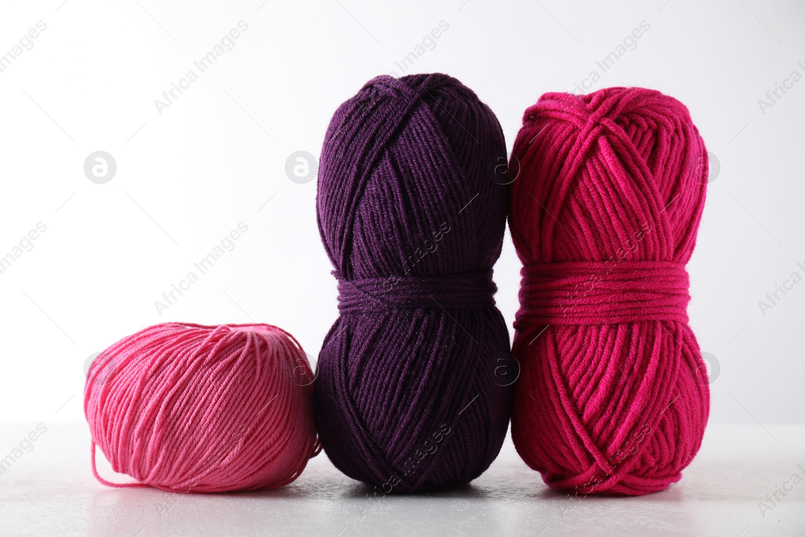 Photo of Many soft skeins of yarn on light grey background