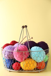 Metal basket with bright yarns on yellow background