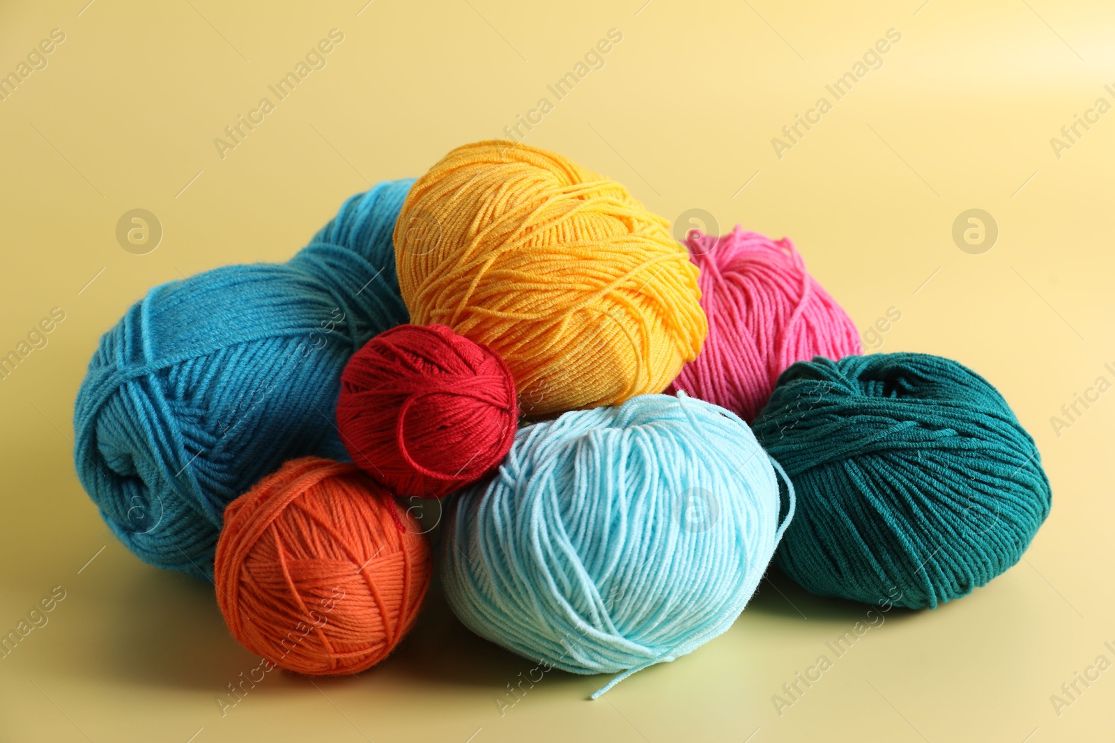 Photo of Many different yarns on yellow background, closeup