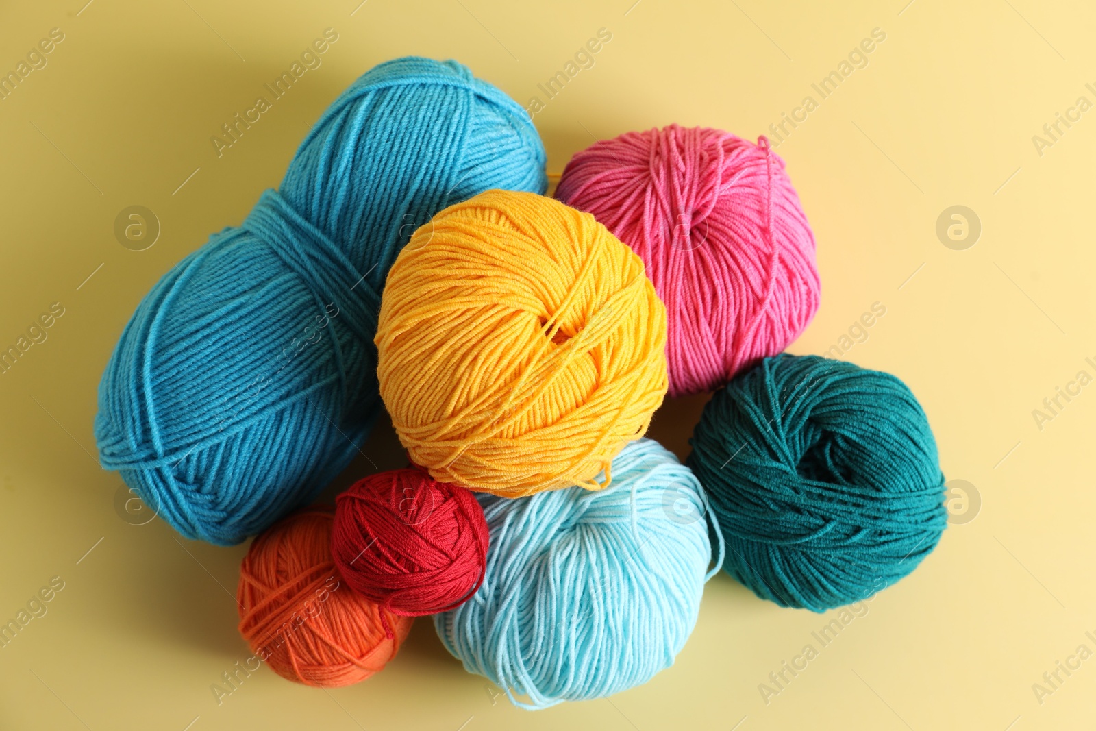 Photo of Many different yarns on yellow background, flat lay