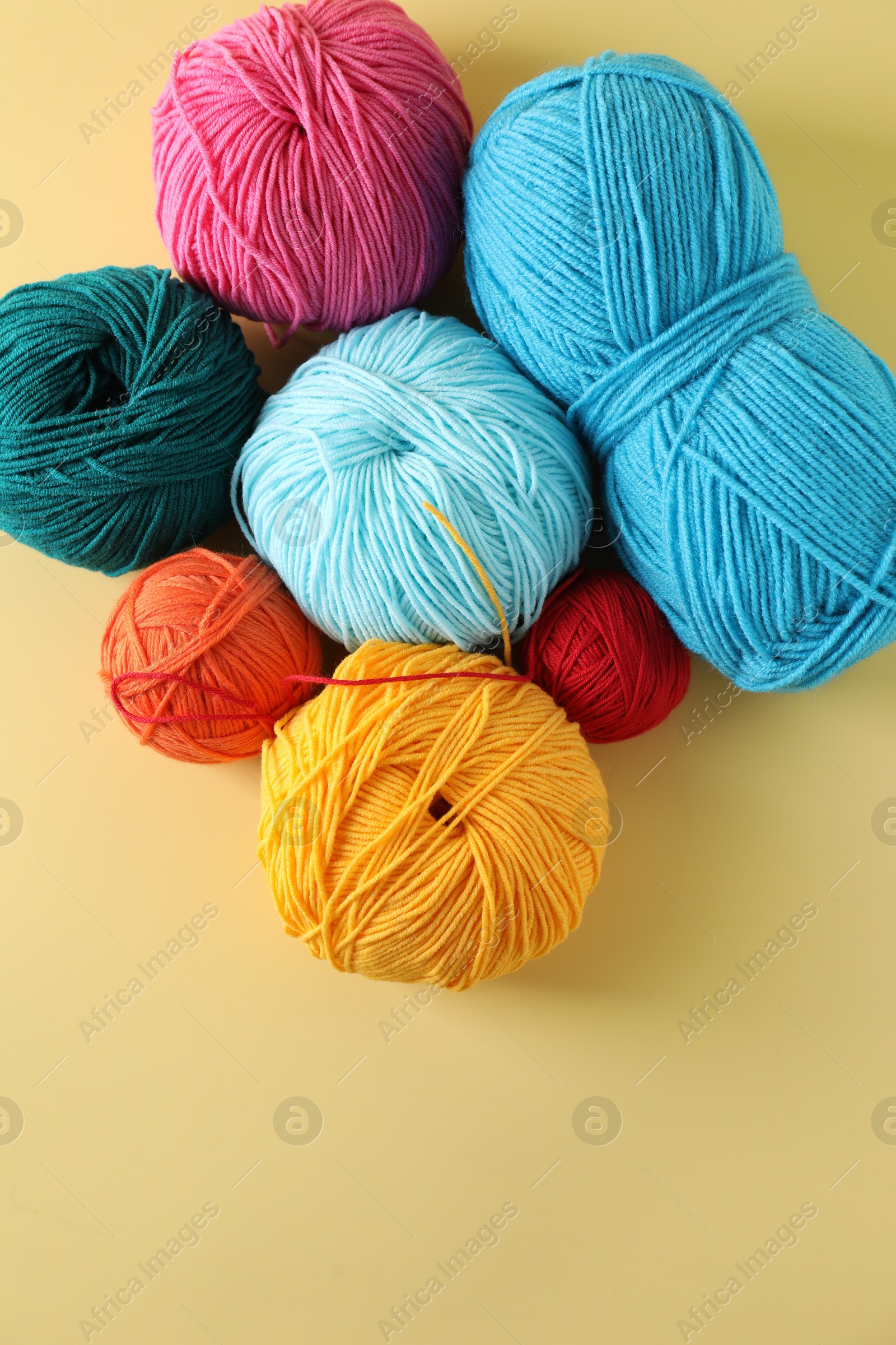 Photo of Many different yarns on yellow background, flat lay. Space for text