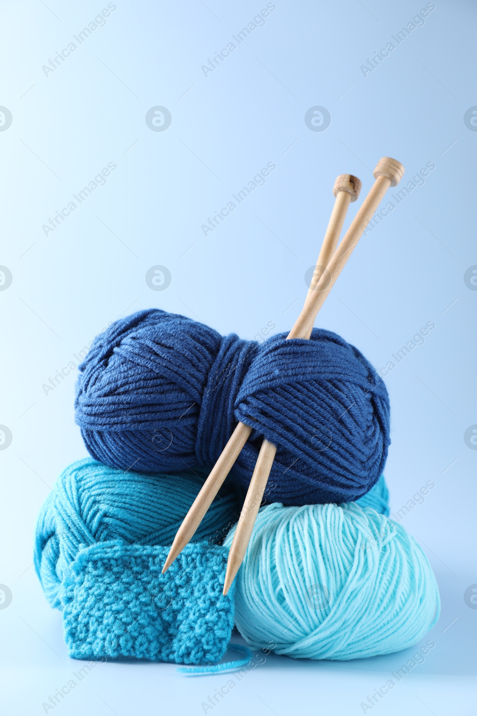 Photo of Different yarns, knitting needles and pattern sample on light background