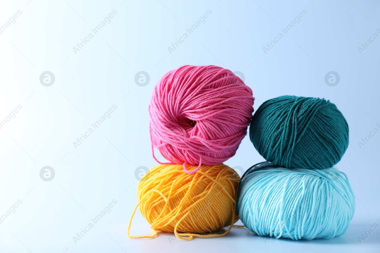 Photo of Colorful yarns on light background. Space for text