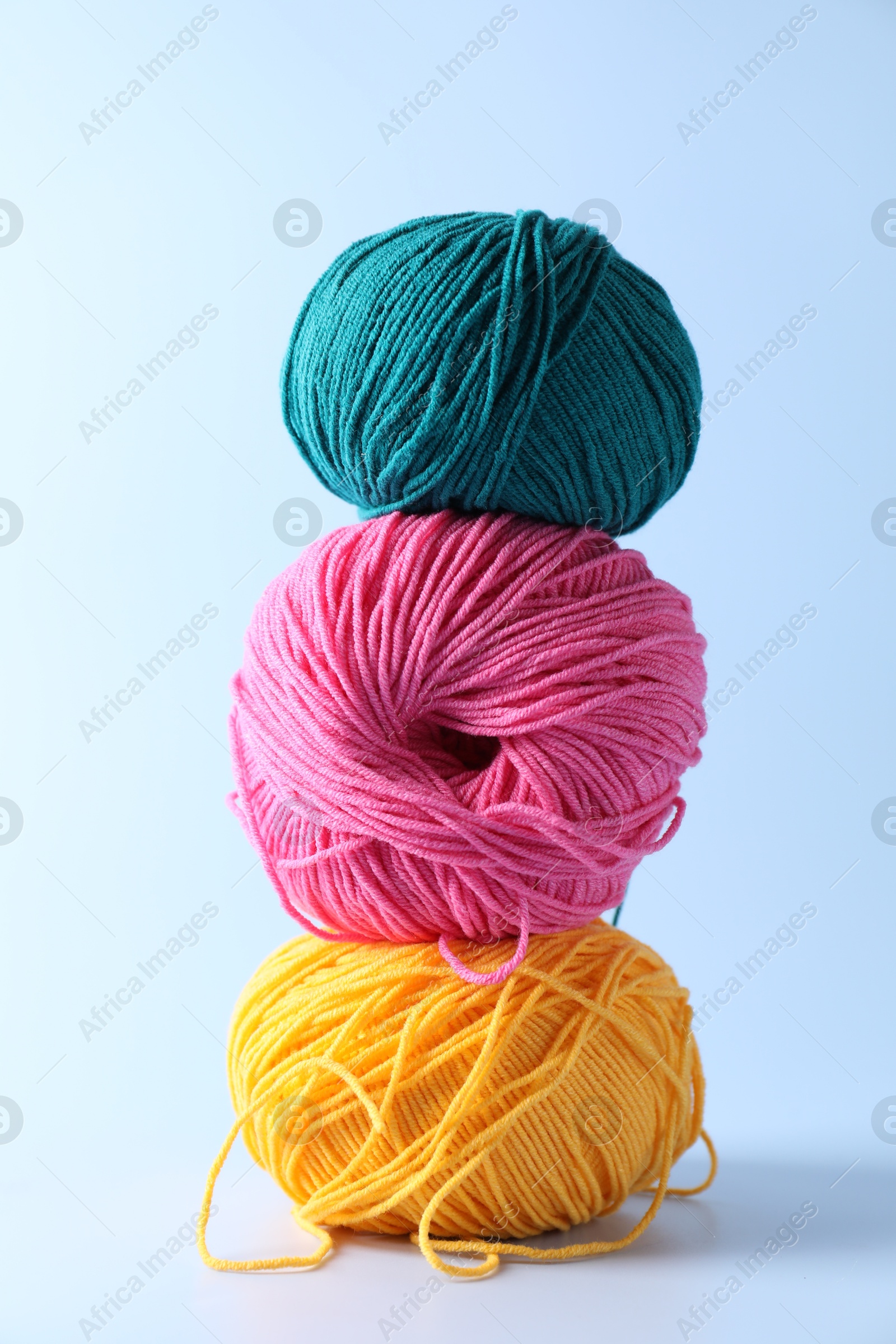 Photo of Stack of colorful yarns on light background