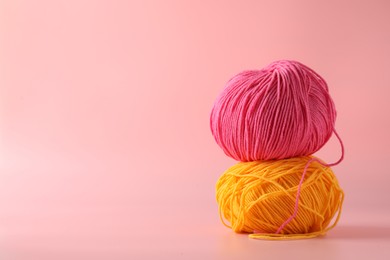 Photo of Colorful yarns on pink background. Space for text