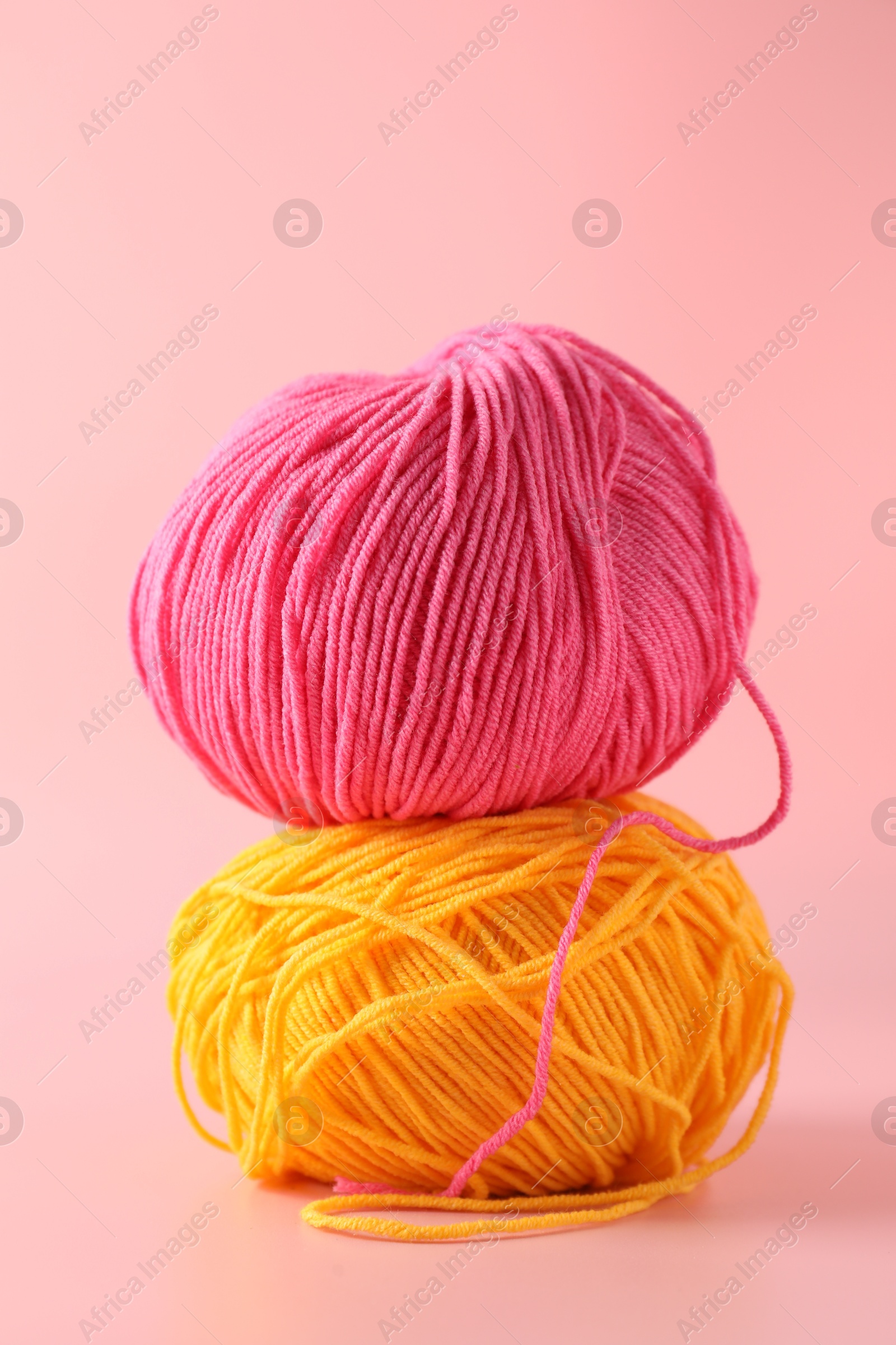 Photo of Colorful yarns on pink background. Knitting material