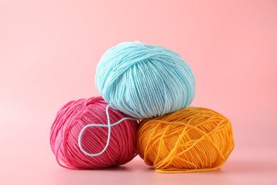 Photo of Different colorful yarns on pink background, closeup