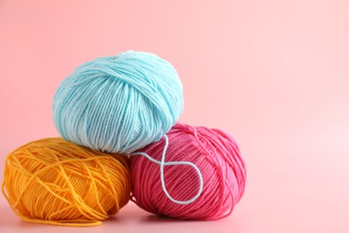 Photo of Different colorful yarns on pink background, closeup. Space for text