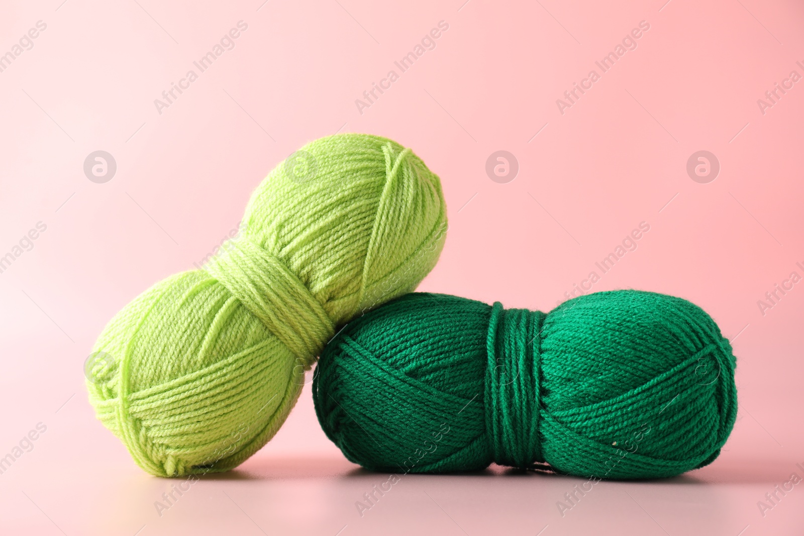 Photo of Different colorful yarns on pink background, closeup